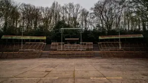 Tuščios žiūrovų vietos atvirame teatro amfiteatre miško apsuptyje vasaros vakaro metu