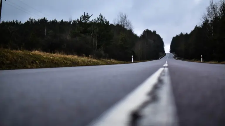 Lietuvos kraštovaizdžio kelias vedantis į Kernavę saulėtą dieną tarp žalių laukų