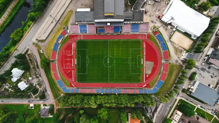 Vaizdas iš viršaus į futbolo stadioną ir bėgimo takus Lietuvoje.