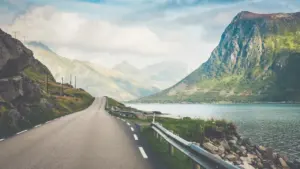 Vaizdingas kelias Norvegijos kalnuose, puikiai atspindintis kelionės planavimo ir kaštų tematiką.