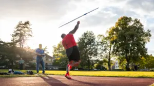 Sportininkas treniruojasi lengvosios atletikos stadione ruošdamasis svarbioms disko metimo varžyboms.