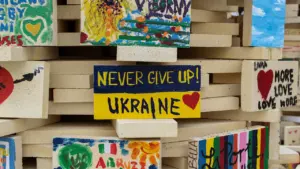 Mediniai blokeliai su Ukrainos vėliavos spalvomis ir palaikymo žinutėmis apie paramą Ukrainai.