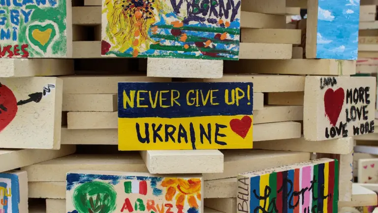 Mediniai blokeliai su Ukrainos vėliavos spalvomis ir palaikymo žinutėmis apie paramą Ukrainai.