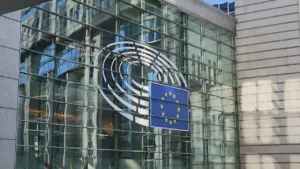 Europos Parlamento pastato stiklinis fasadas su Europos Sąjungos vėliava ir simbolika