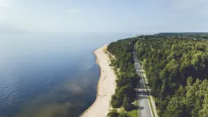 Vaizdas iš oro į pajūrio kelią, besidriekiantį palei Baltijos jūros krantą.