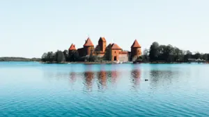 Trakų pilis ant Galvės ežero kranto saulėtą dieną, istorinis Lietuvos valstybės simbolis.